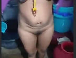 A middle aged Tamil woman removes her saree and presents her body.