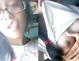An Asian girl is showing her breasts and vagina.