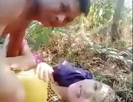 Two lovers make passionate love in the woods.